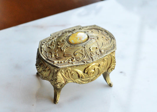Vintage Ornate Gold‑Tone Footed Jewelry Trinket Box – Embossed Floral Metal Casket with Cabochon Lid – Victorian Revival – 1950s–1970s